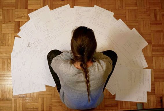 Immagine di ragazza che legge alcuni fogli sparsi sul pavimento